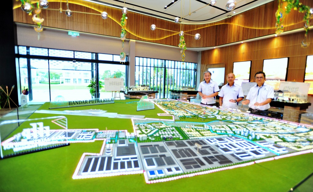 Lim (centre) poses at the Bandar Putra Kulai township master plan model located in IOI Galleria Kulai.