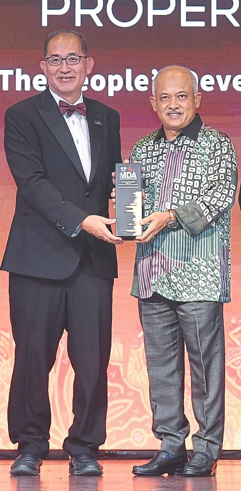 Paramount Corporation Bhd deputy group chief executive officer Beh Chun Chong  (left) receiving the MDA 2025 trophy from Housing and Local Government Ministry secretary-general Datuk Wira M Noor Azman Taib.